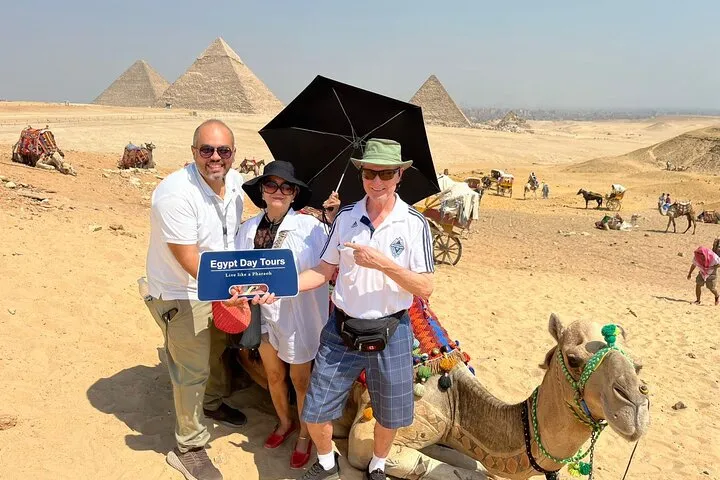 Travelers with a camel on the Giza plateau on a 7-day private luxury Egypt tour, Giza, Egypt