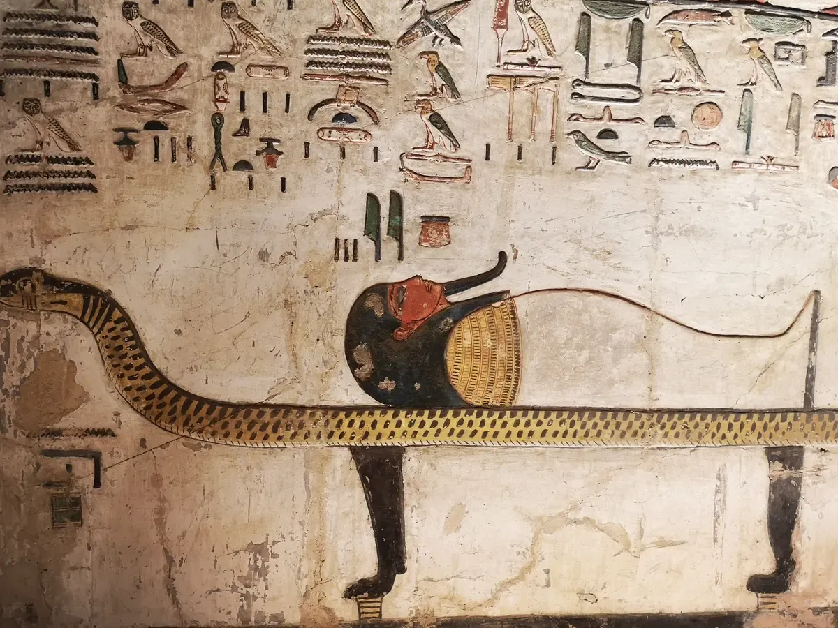 A painted serpent and hieroglyphs on a wall inside the tomb of Seti I on a luxury Egypt tour, Valley of the Kings, Luxor, Egypt