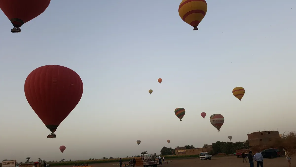 Hot air balloons drifting over Luxor at dawn on a luxury Egypt tour, Luxor, Egypt