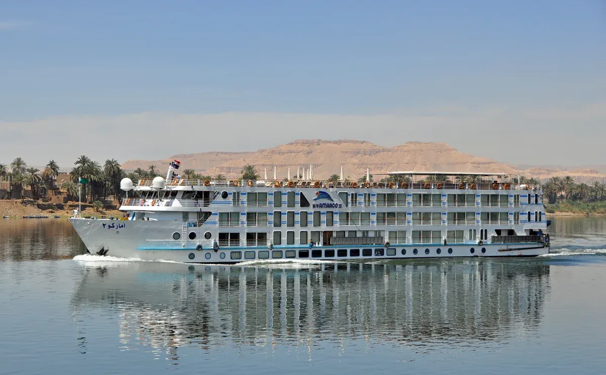 A multi-deck cruise ship sailing on the Nile on a luxury Egypt tour, Nile River, Egypt
